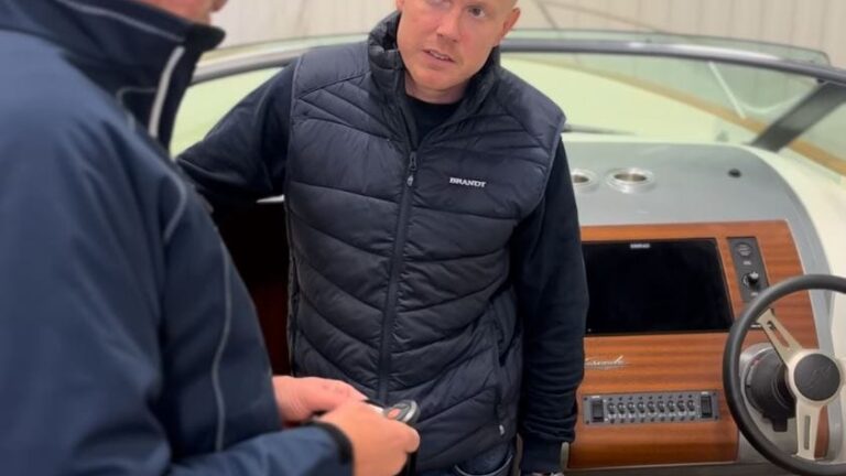 En säljare från Brandt Båt talar med en kund om båtförsäljning.