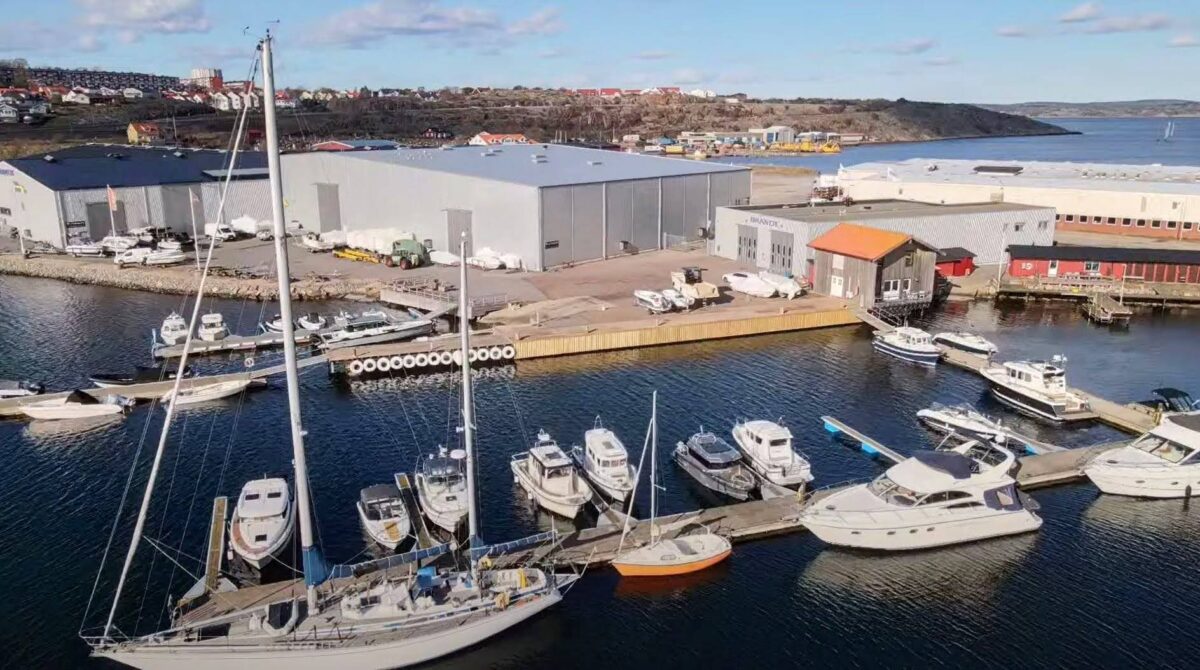 Drönarvy över Brandt Båts stora anläggning vid en hamn i Lysekil.